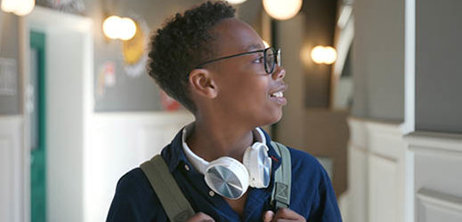 student in hallway looking out window